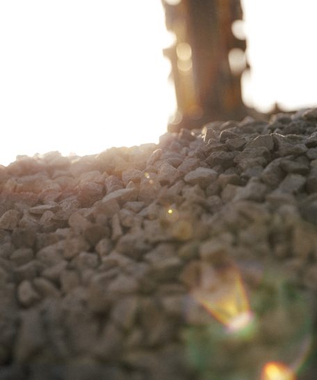 Ambientebild einer Baugrubensicherung: Sonne hinter einem Berg Steine